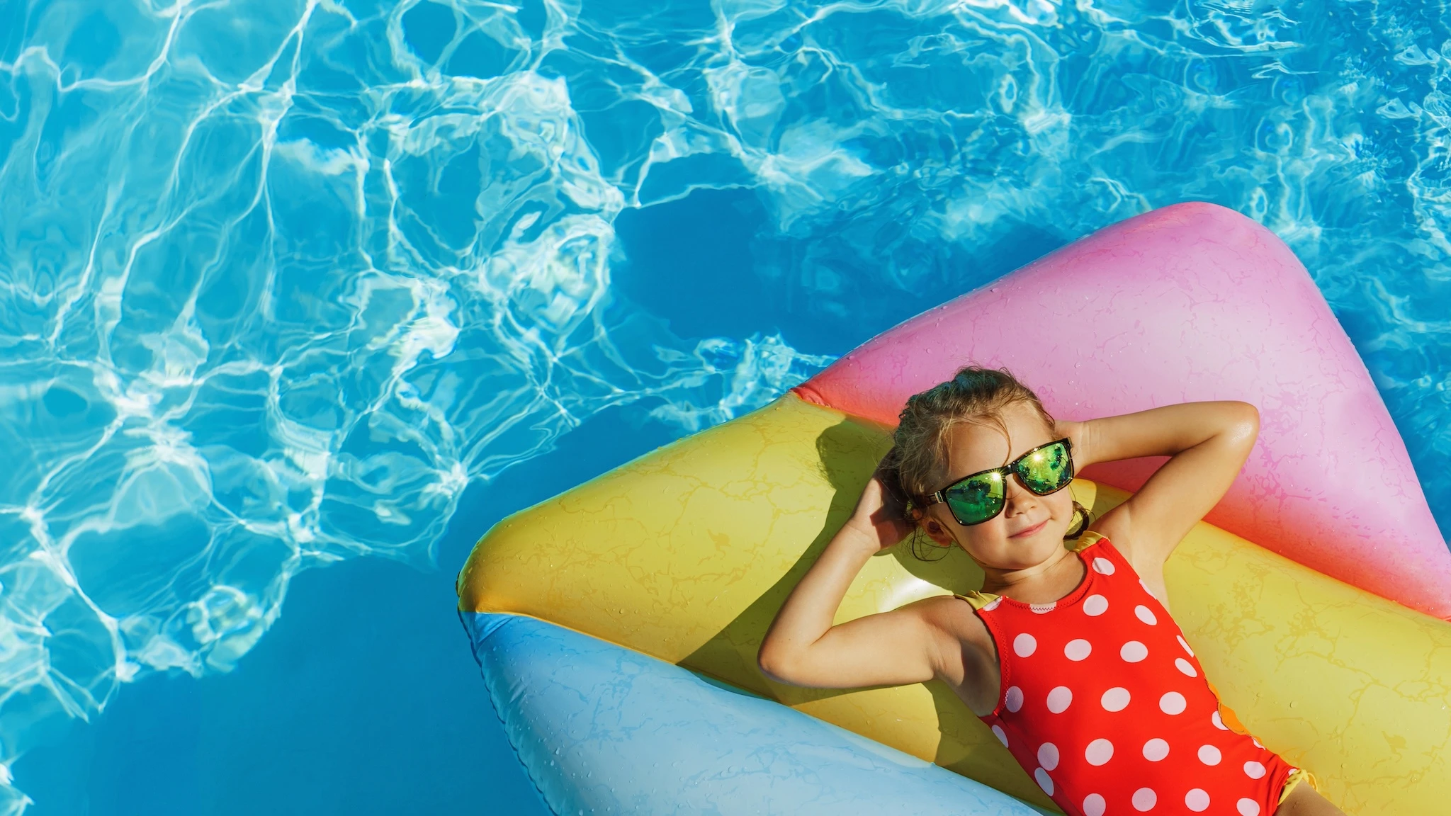 Familie mit Kindern am Pool einer Ferienanlage in Italien