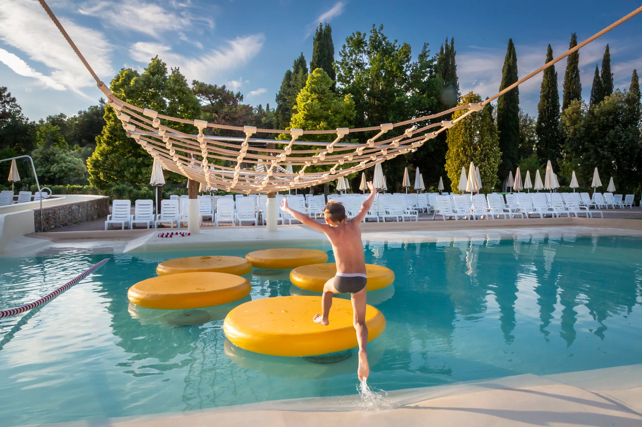 A child jumping on an inflatable toy in the swimming pool