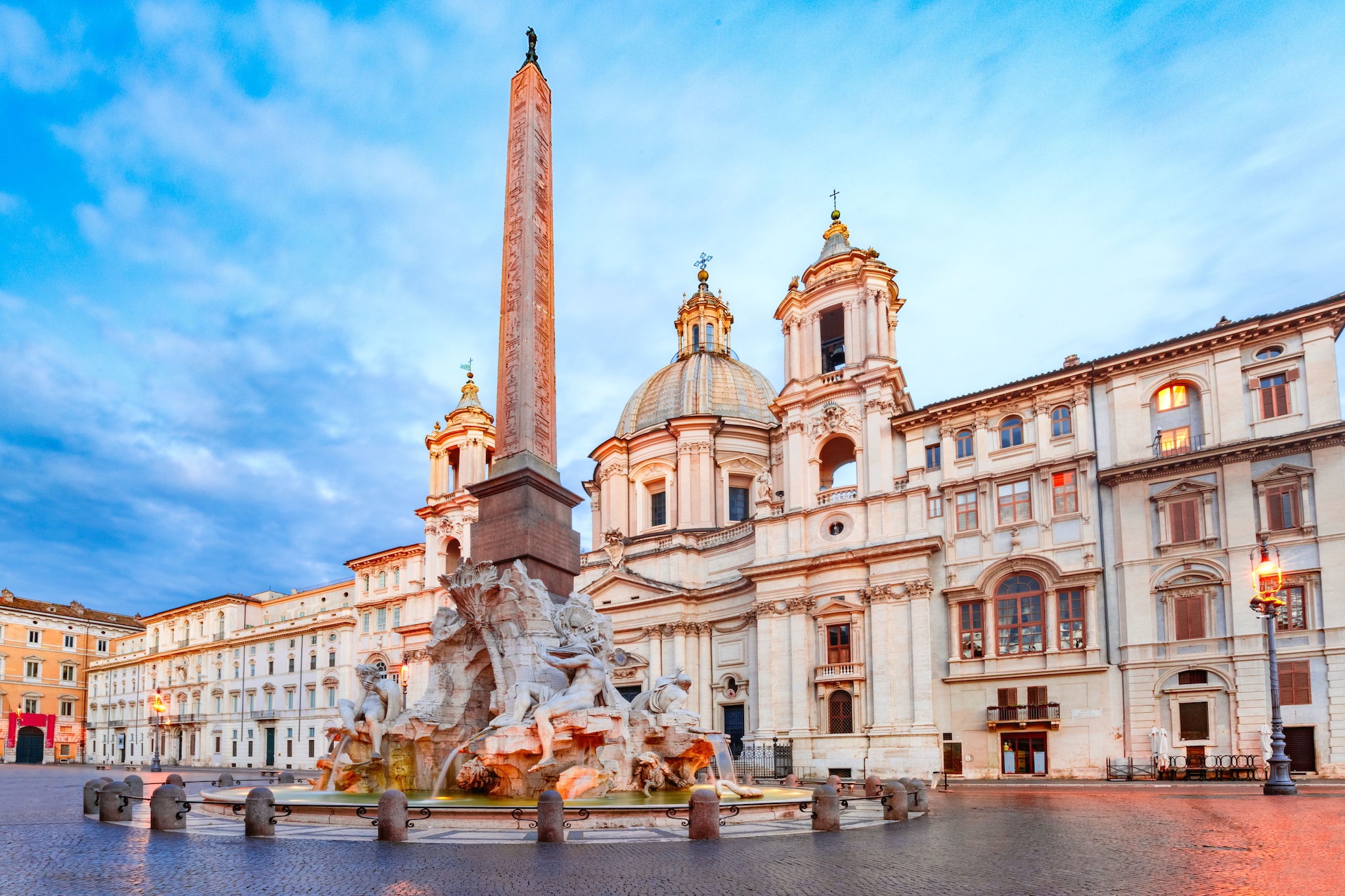 La maestosa Fontana dei Quattro Fiumi al centro di Piazza Navona con l'obelisco che si innalza dalla scogliera di travertino
