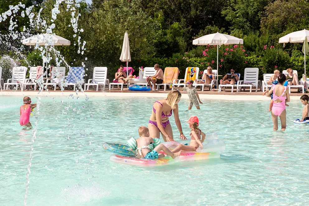 Familie im Pool eines Camping Village in Italien
