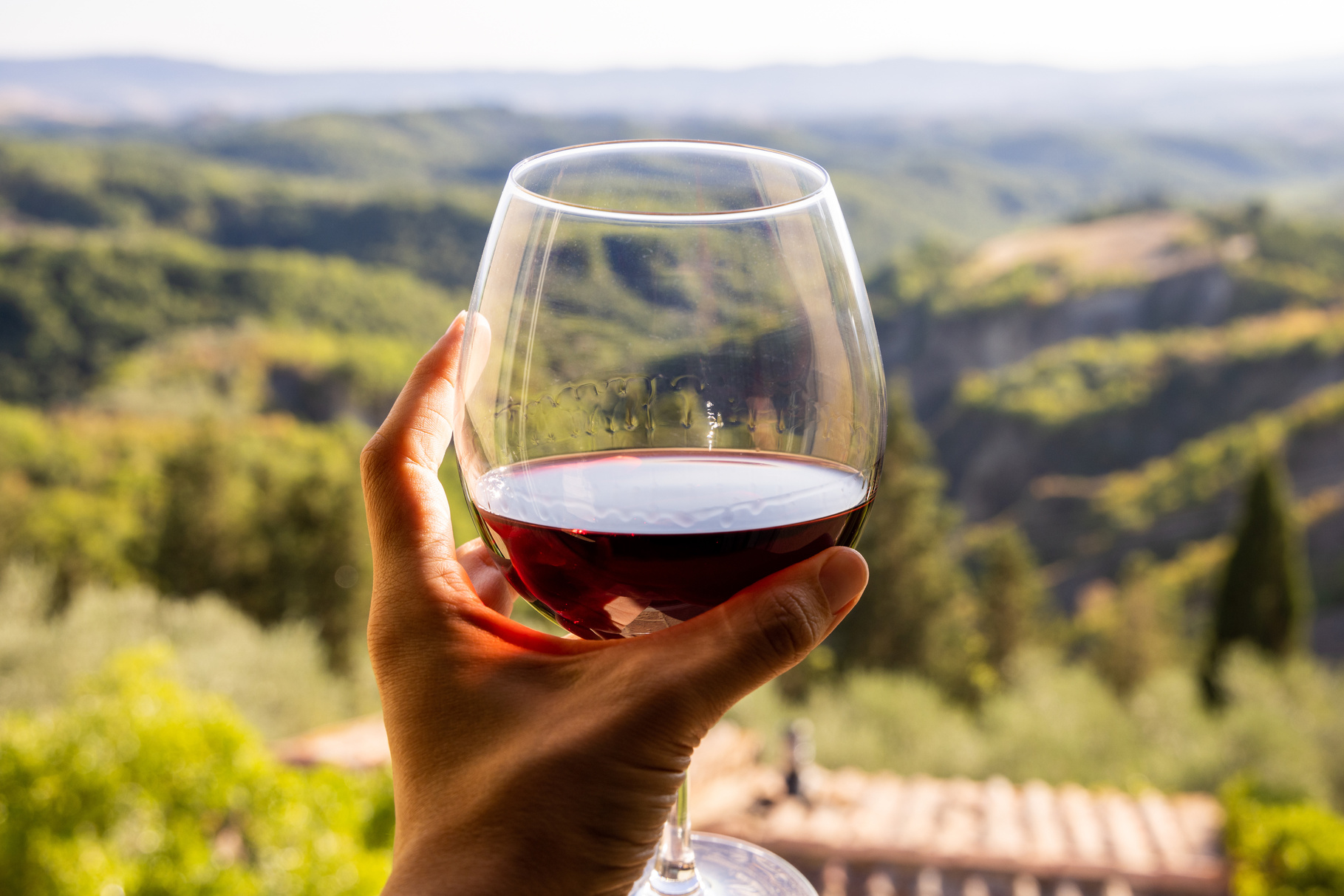 Ein Glas Rotwein und Blick auf die toskanischen Hügel